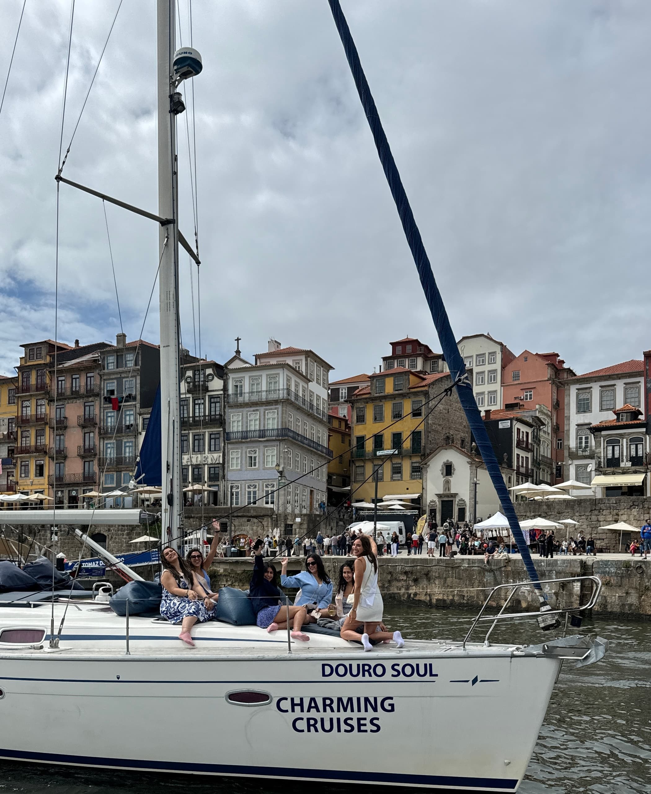 Sailboat cruising past colorful Ribeira buildings in Porto