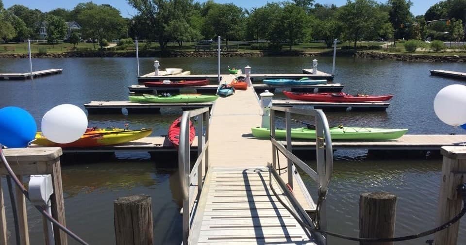 Kayak and paddleboard launch dock framed by trees and water