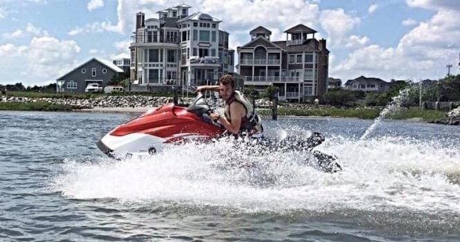 Jet ski cutting through water near coastal homes and marina