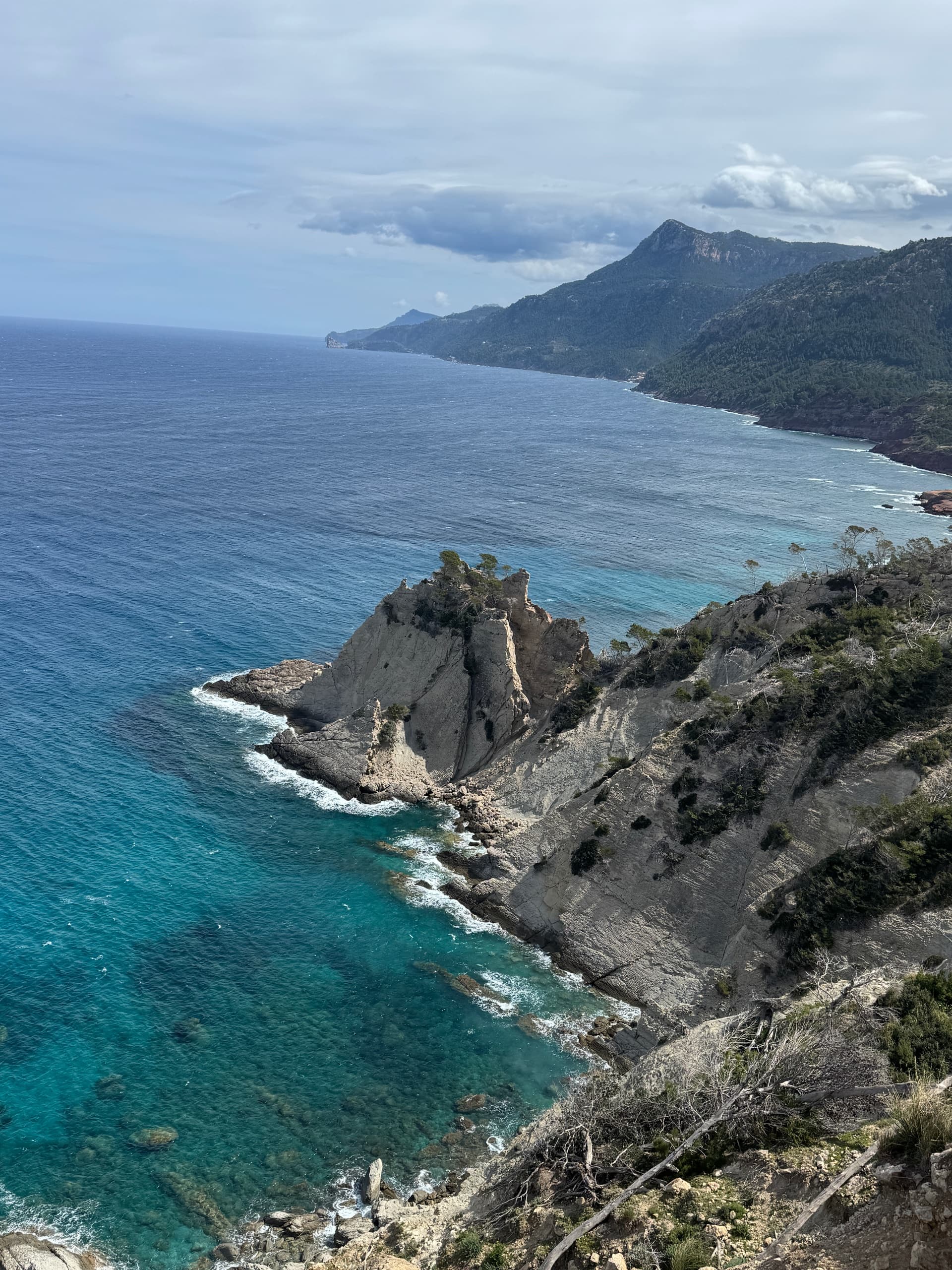Cliffside viewpoint over clear sea with dramatic rock formation