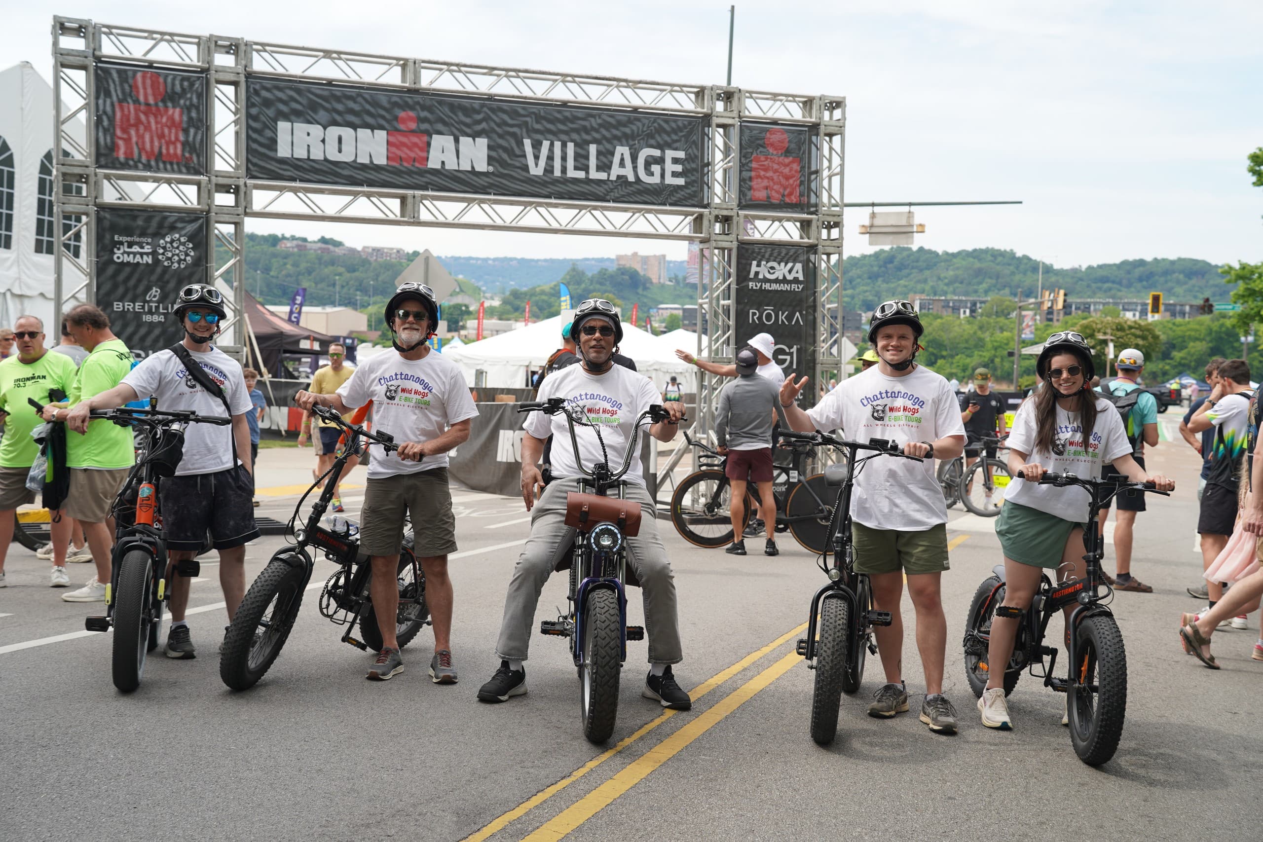 Community e-bike riders lined at race start under event arch