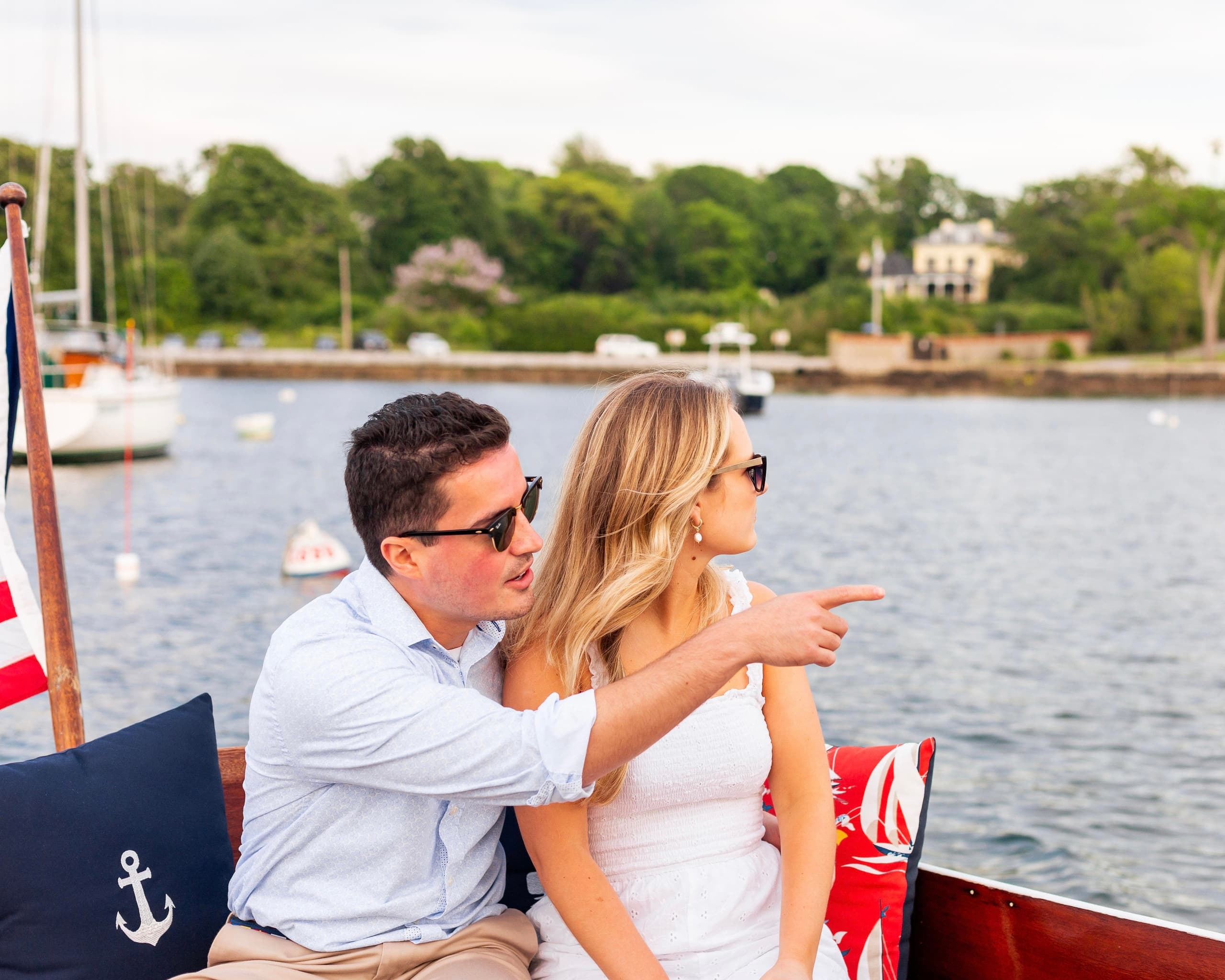 Couple enjoying coastal boat ride pointing toward shoreline view