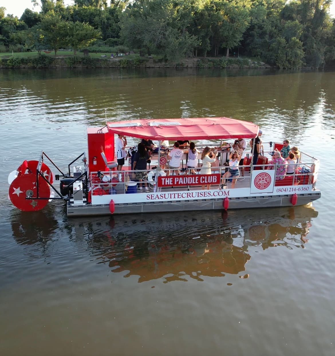 Red paddlewheel party boat offering river cruises with passengers