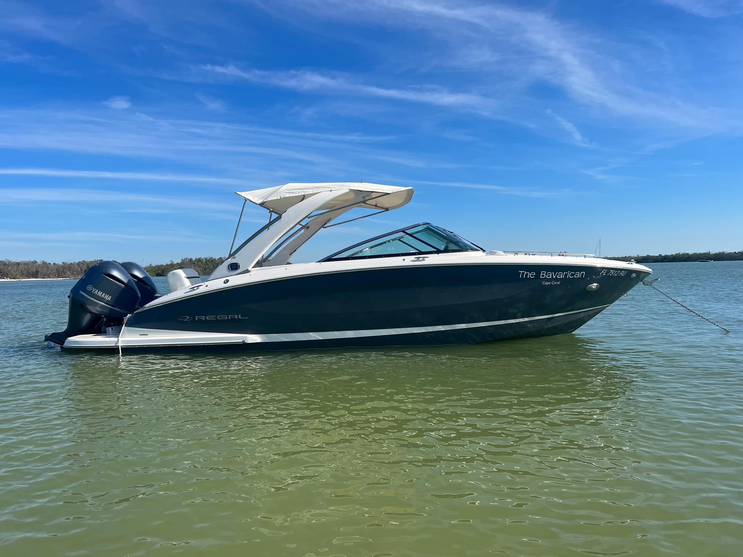 Sport cruiser anchored in clear coastal water under blue sky