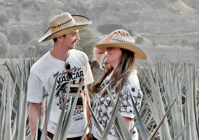 Couple exploring agave field in Mexico, wearing straw hats