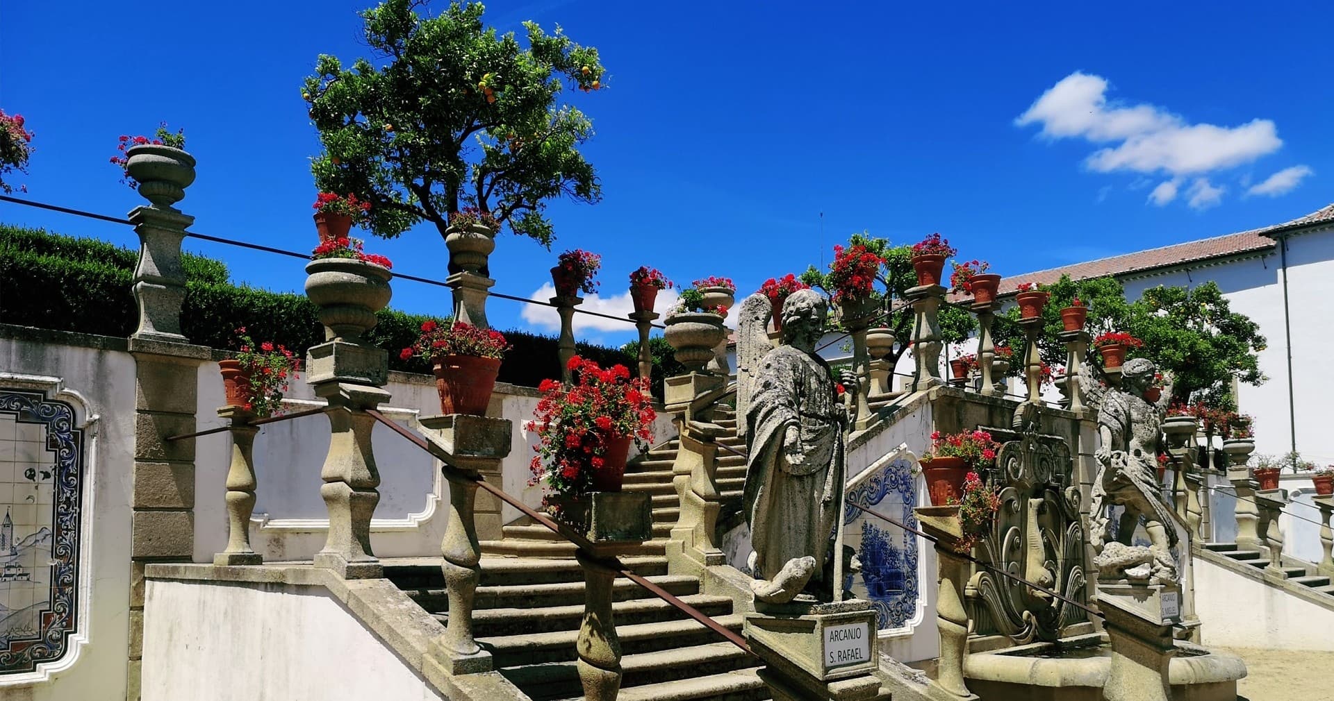 Decorative garden stairway with statues and bright floral displays