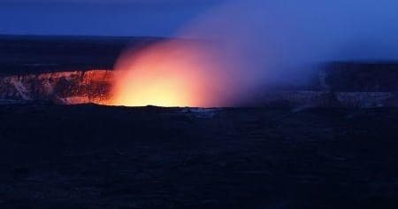 Volcanic crater glowing orange at dusk on a Hawaiian volcano rim