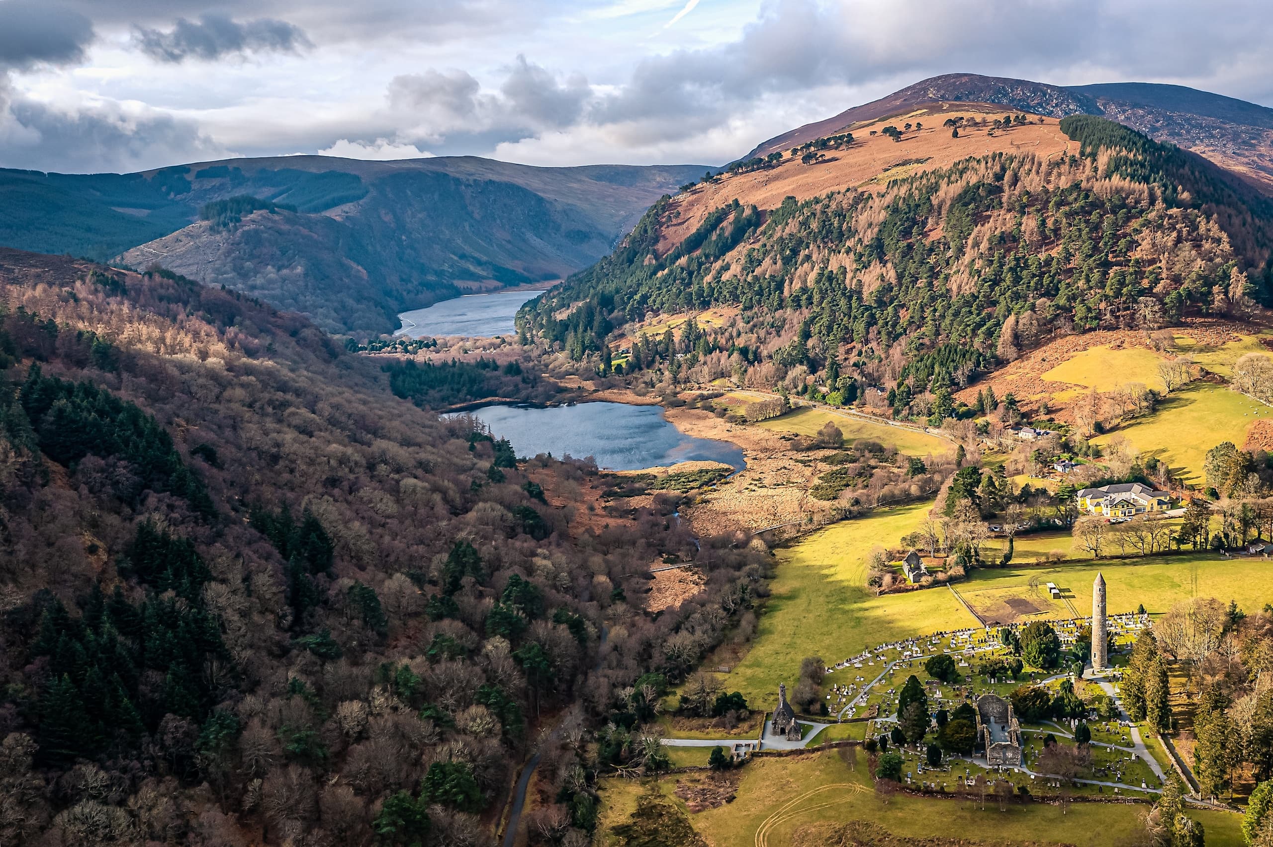 Valley landscape with ruins and winding lake in Irish hills