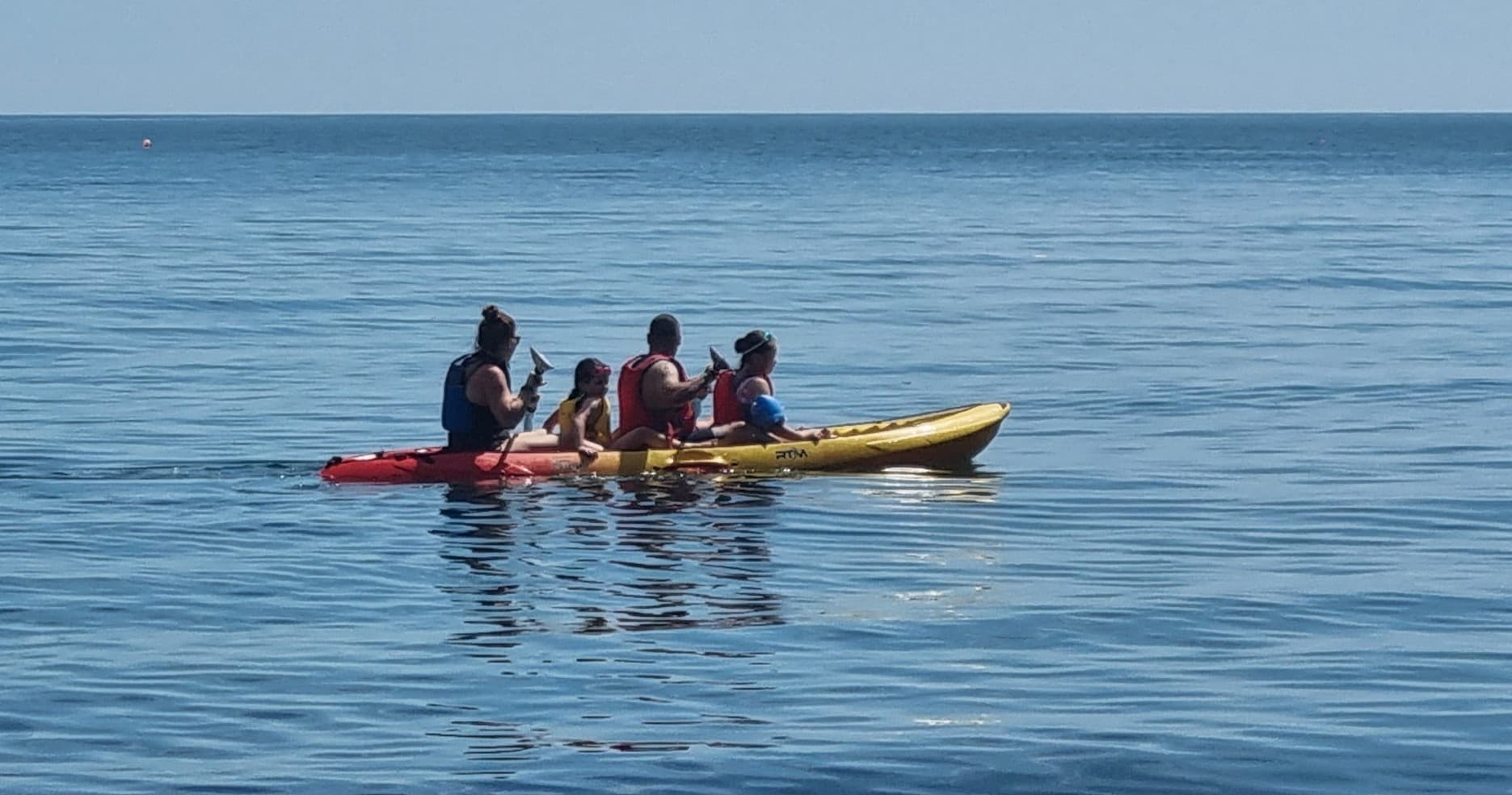 Group tandem kayak outing on calm coastal sea waters