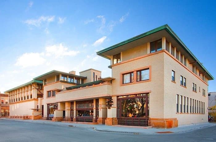 Historic hotel exterior on sunny park street, inviting overnight stay