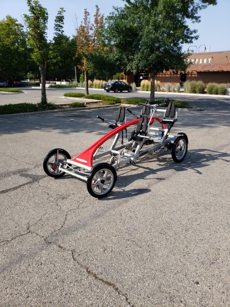 Four-wheel rental quadricycle parked in suburban lot near trees