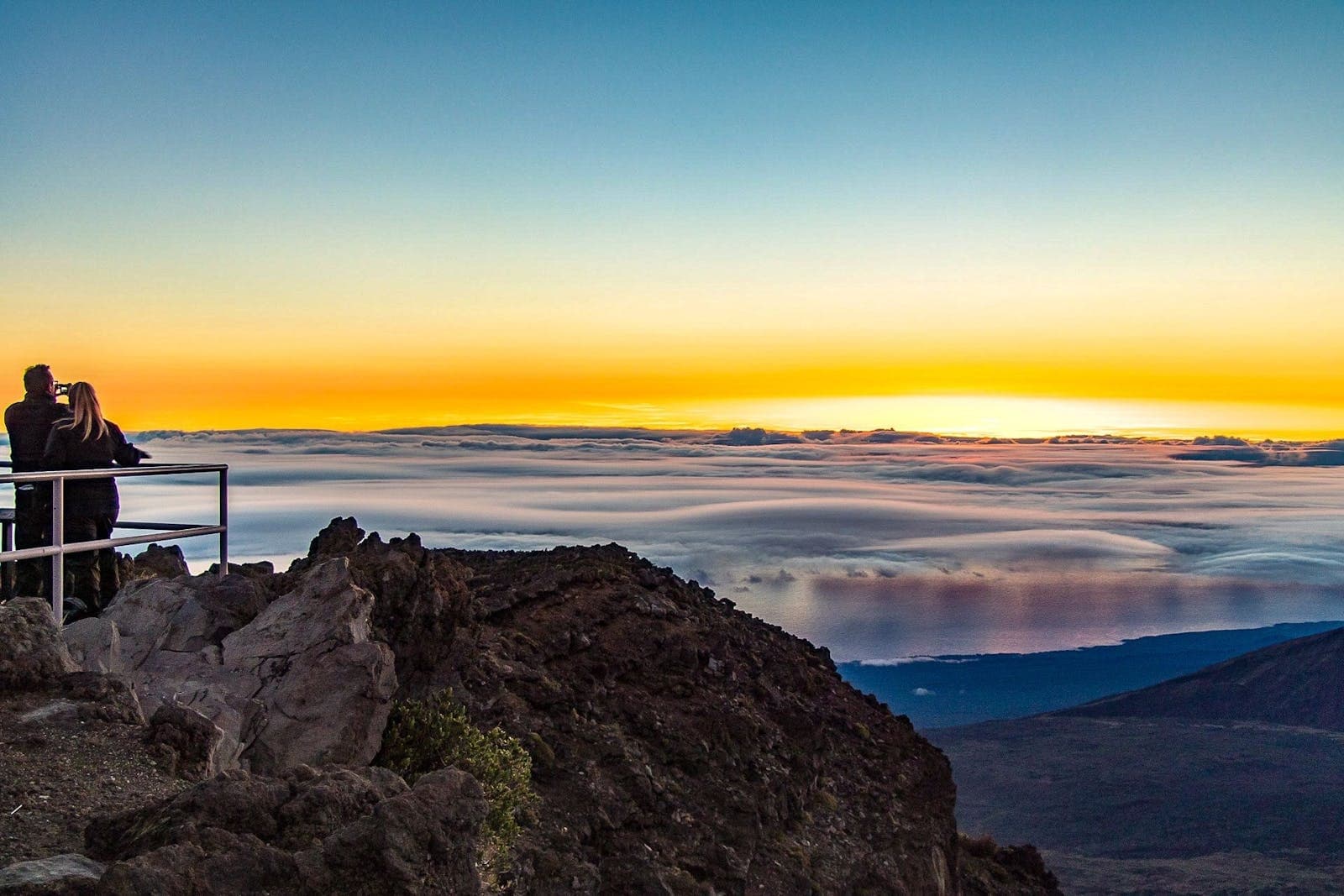 Sunset vista from mountain lookout in Maui, travelers watching