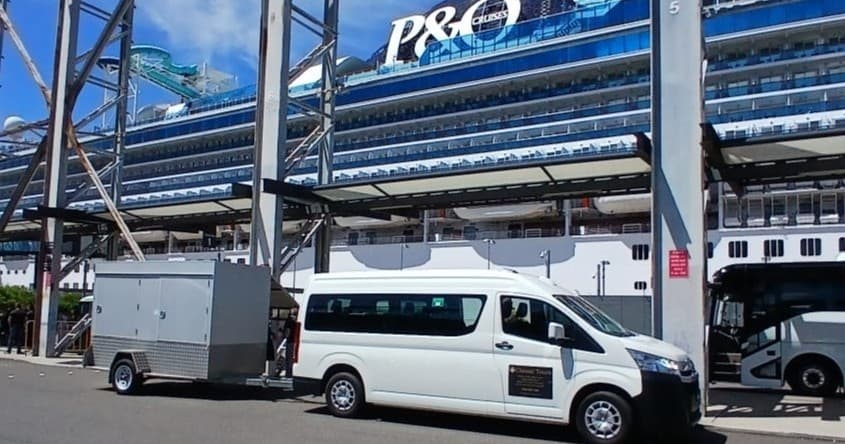 Shuttle van parked at cruise terminal by ocean liner