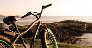 Coastal cruiser e-bike parked with ocean view at golden hour