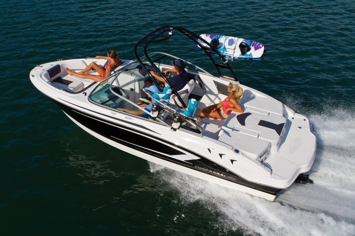 Powerboat towing wakeboarders during high-speed lake session