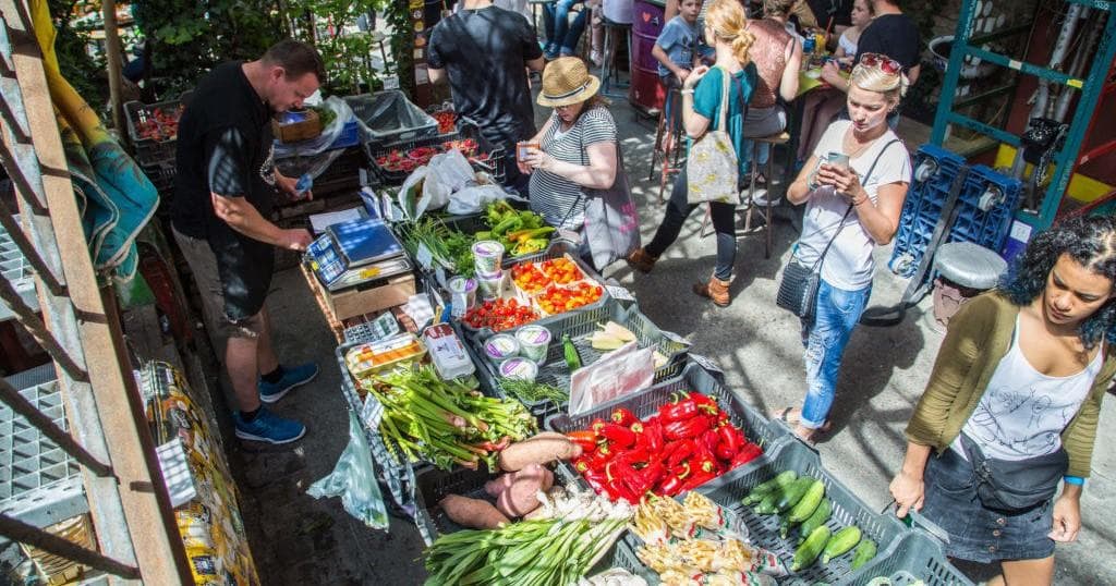 Outdoor farmers market with vendors selling fresh produce