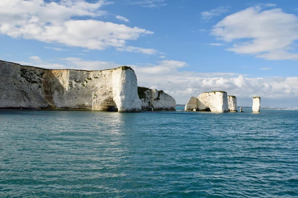 Scenic chalk cliffs and sea at Swanage coastline, boat views