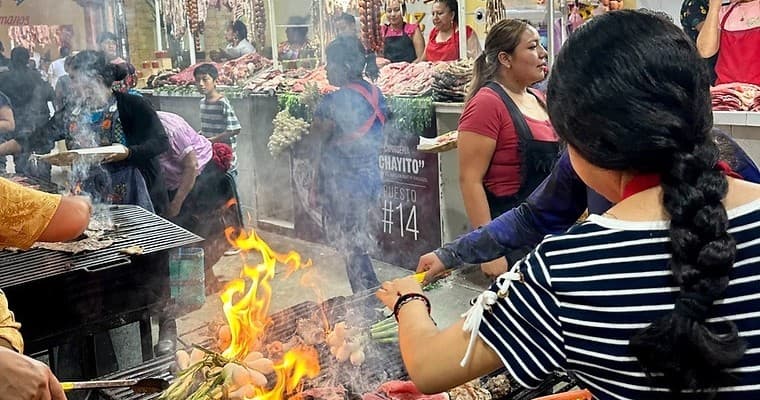 Street food vendors grilling at bustling Oaxaca outdoor market
