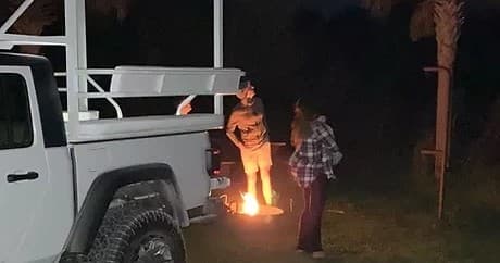 Nighttime campfire beside truck during an Everglades jeep trip