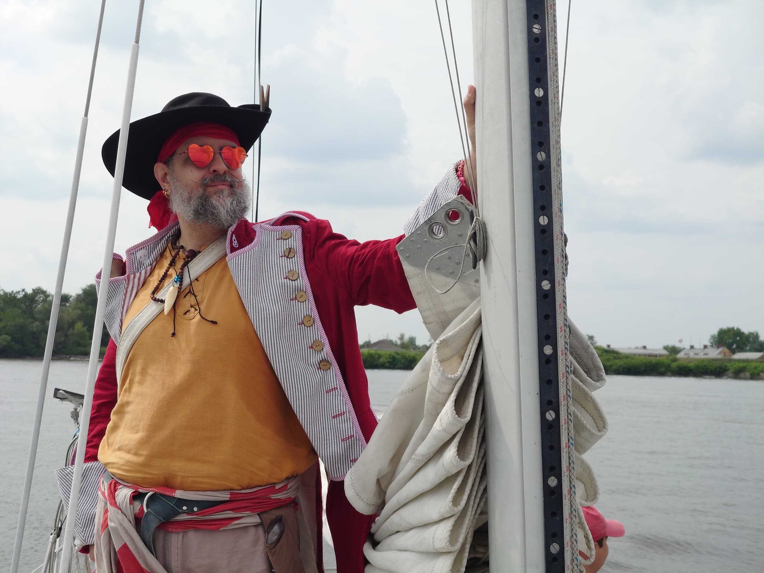 Skipper in pirate costume posing on sailboat deck during day