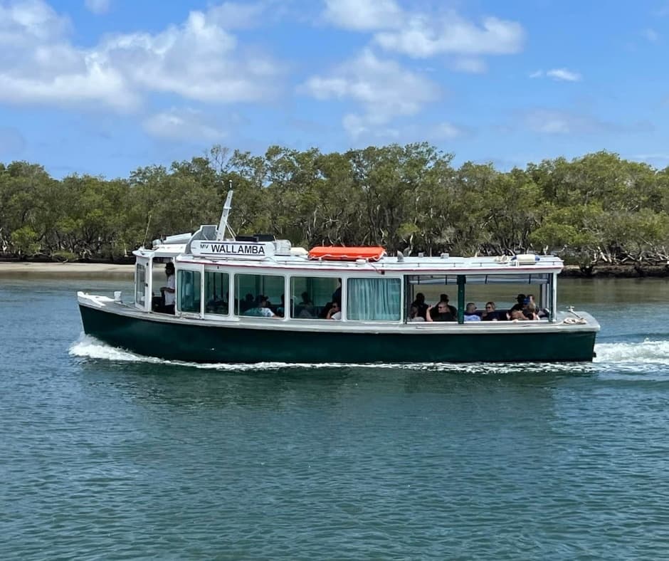 Sightseeing ferry on calm river near Tea Gardens shoreline