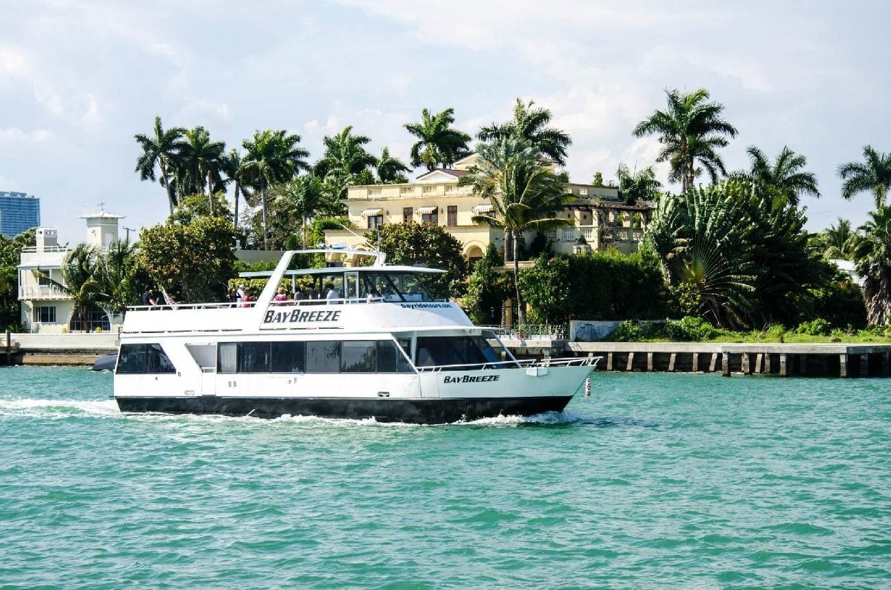 Sightseeing yacht cruising Biscayne Bay past palm-lined shore