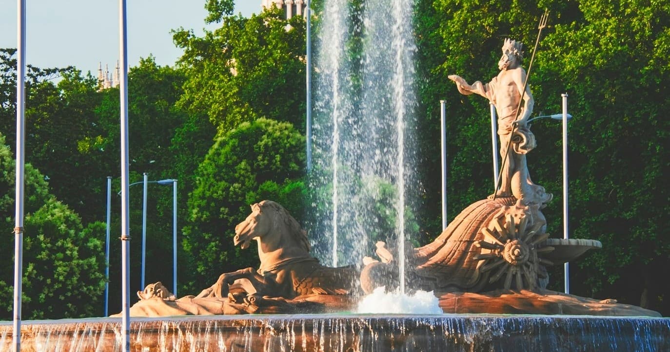 Ornate fountain with statues in Madrid park during guided city tour