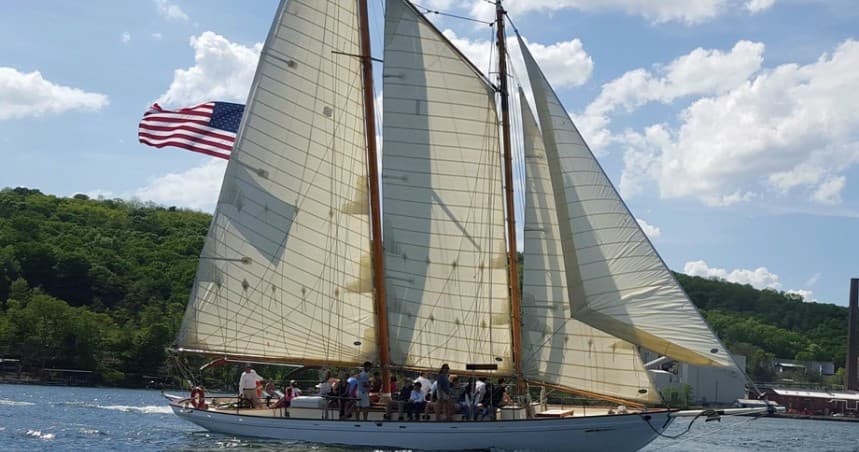 Tall schooner with American flag carrying passengers on coastal sail
