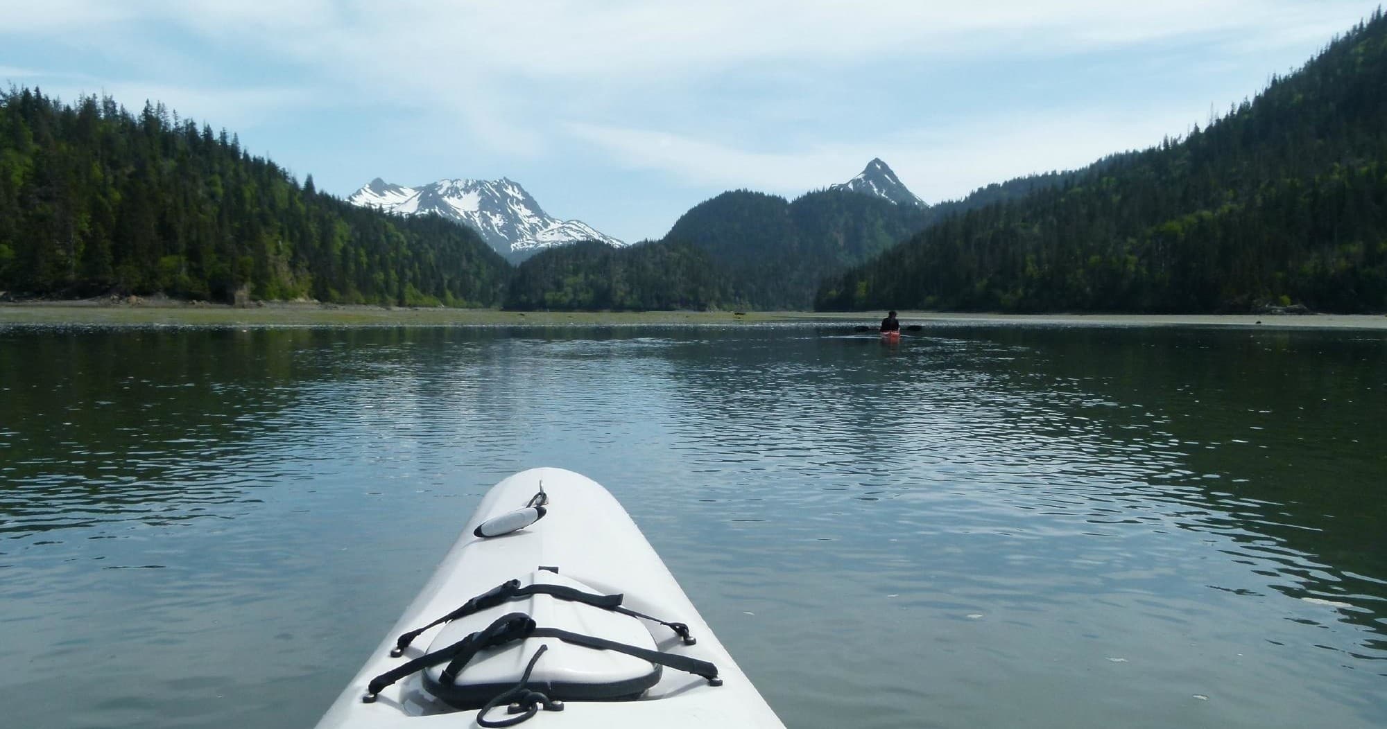 Kayak bow on calm alpine lake with mountain views in Alaska