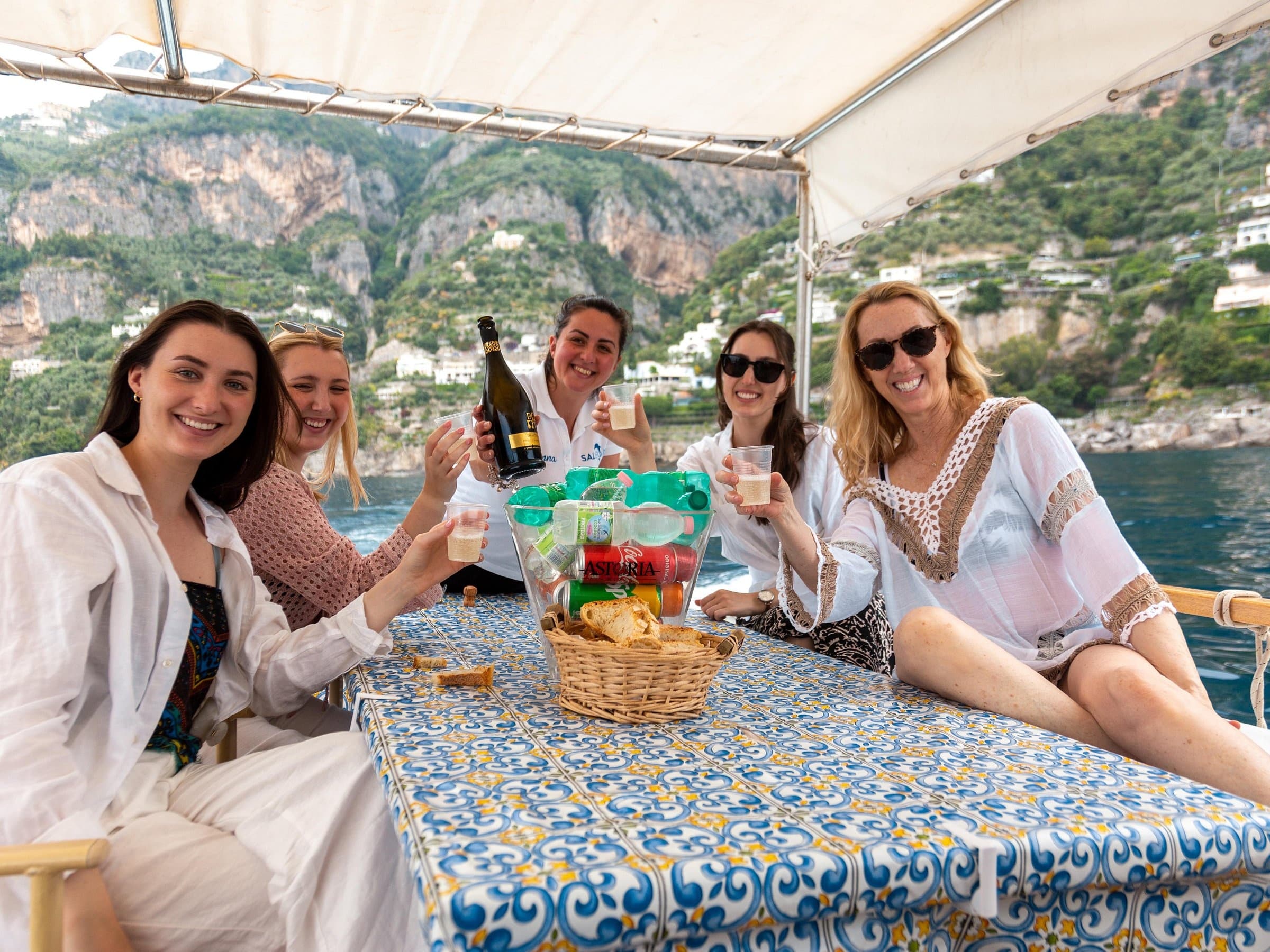Friends relaxing on private boat with Amalfi Coast views from Sorrento
