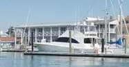Motor yacht docked at sunny coastal marina for private charters