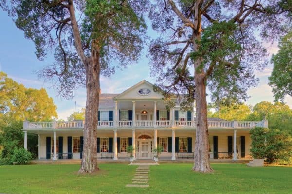 Historic southern mansion exterior on expansive lawn, plantation