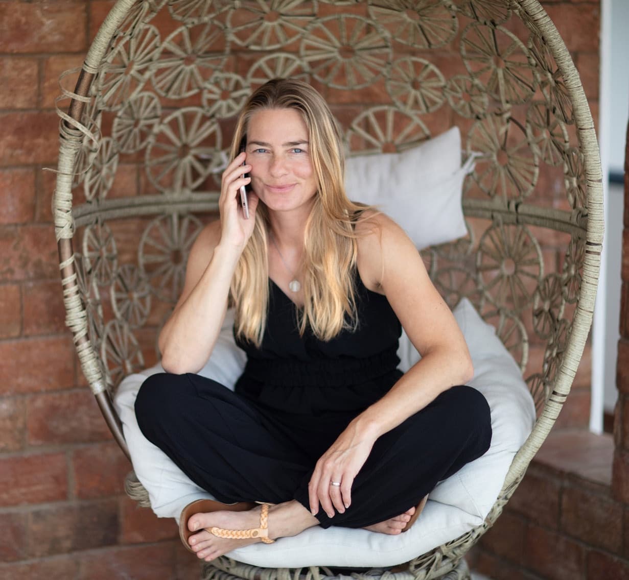 Woman relaxing in wicker hanging chair on Algarve patio