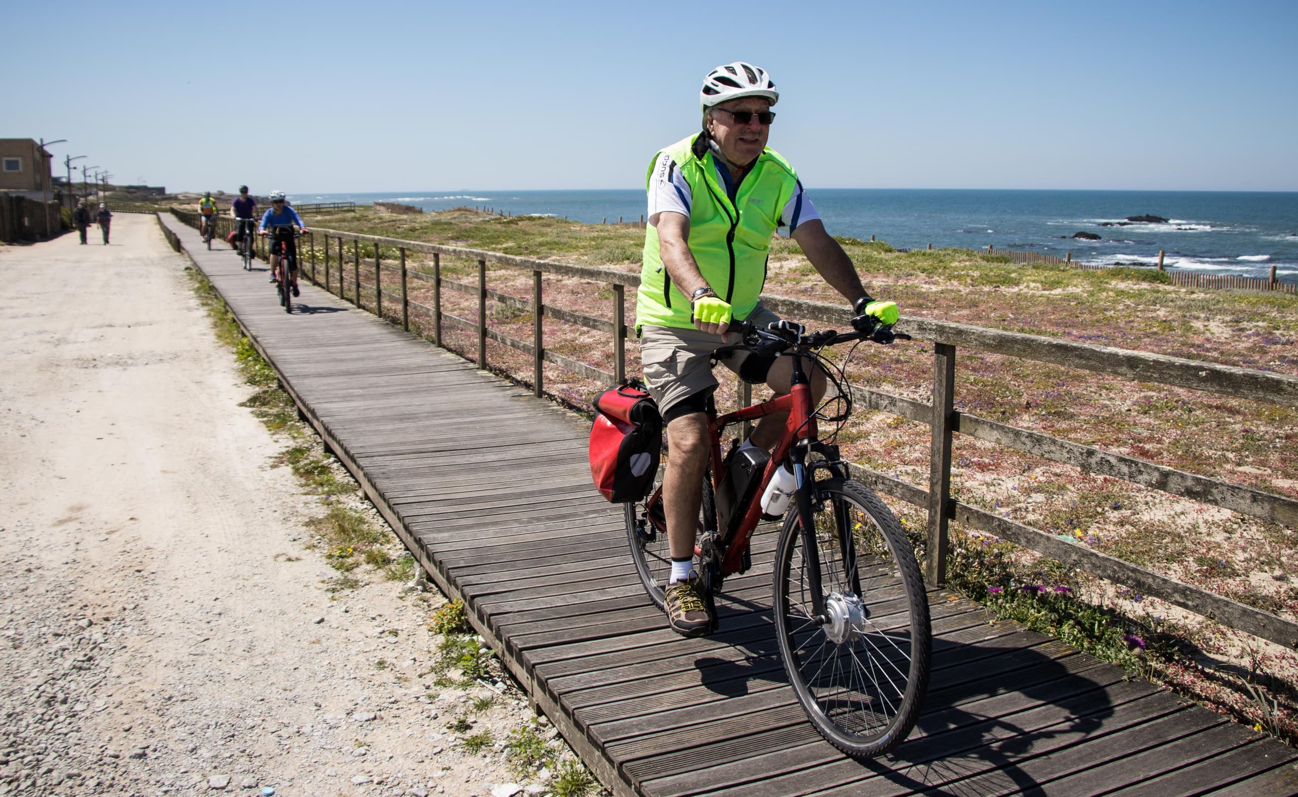 Cyclist riding coastal boardwalk with ocean views in Portugal