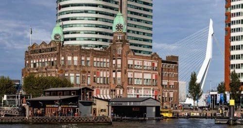 Historic waterfront and Erasmus Bridge skyline in Rotterdam harbor