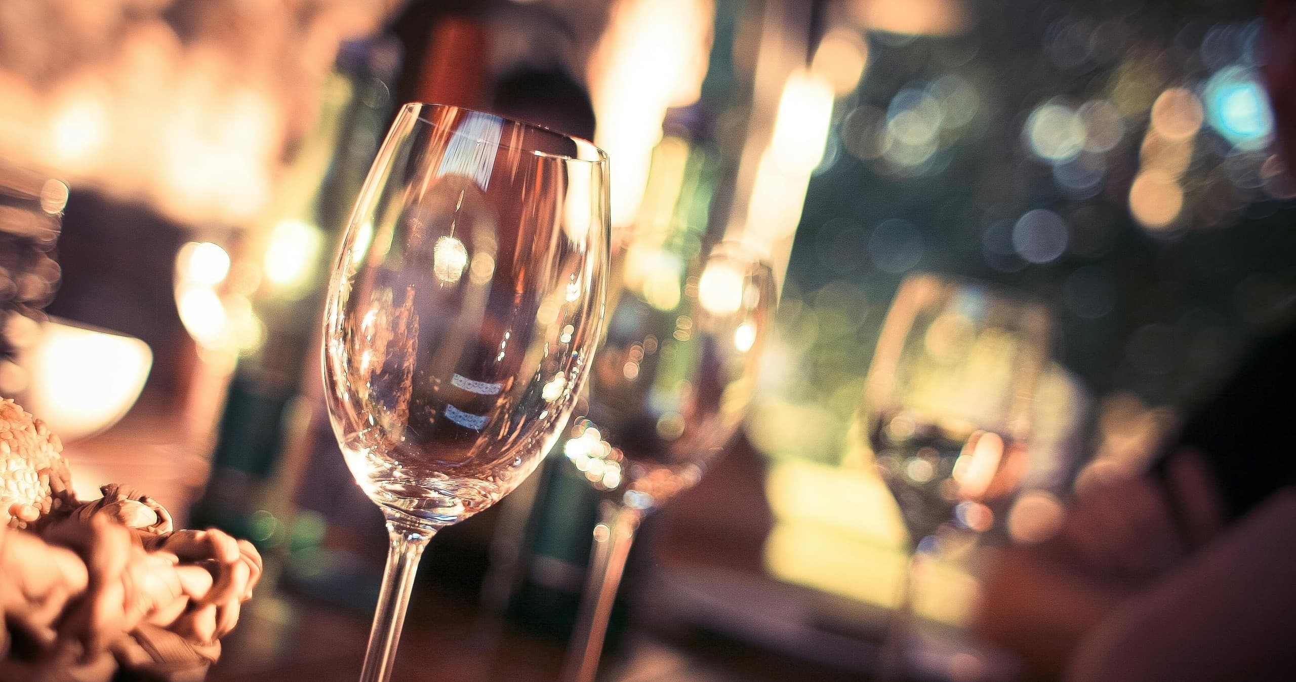 Close-up wine glasses with bokeh lights at restaurant celebration