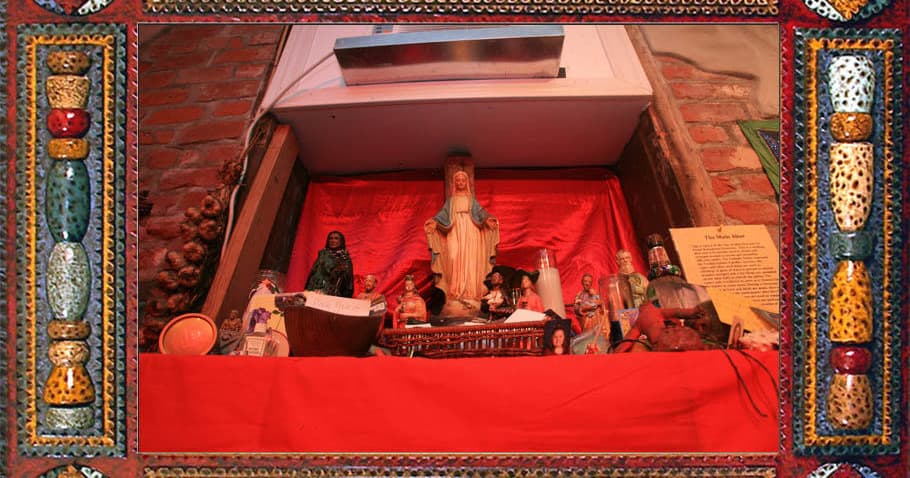 Red-cloth voodoo shrine with statues in museum alcove