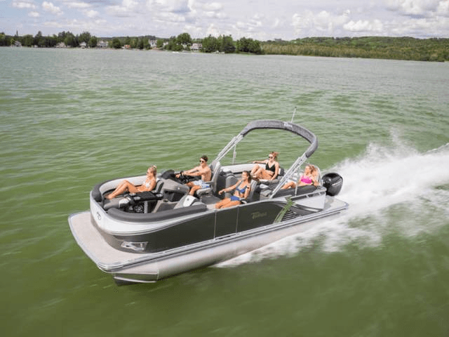 Friends enjoying pontoon cruise across open scenic lake