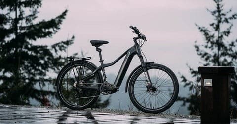 Electric mountain bike parked on dock with misty forest view