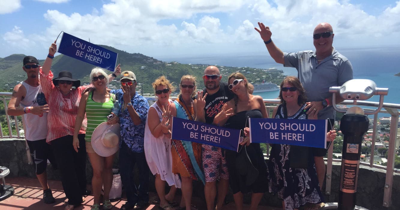 Excursion group cheering at scenic viewpoint with ocean backdrop