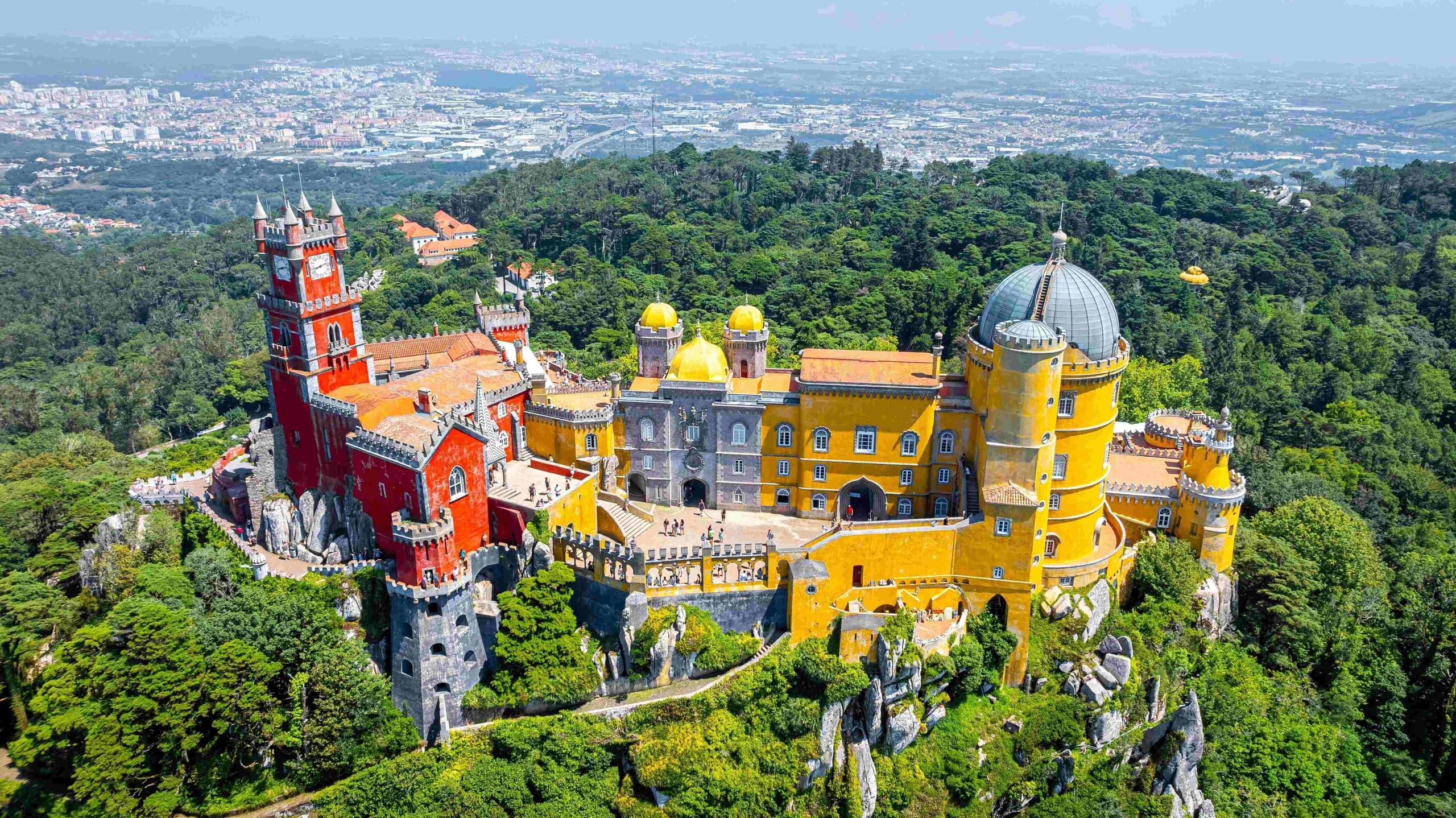 Aerial view of colorful Pena Palace and forested Sintra hills