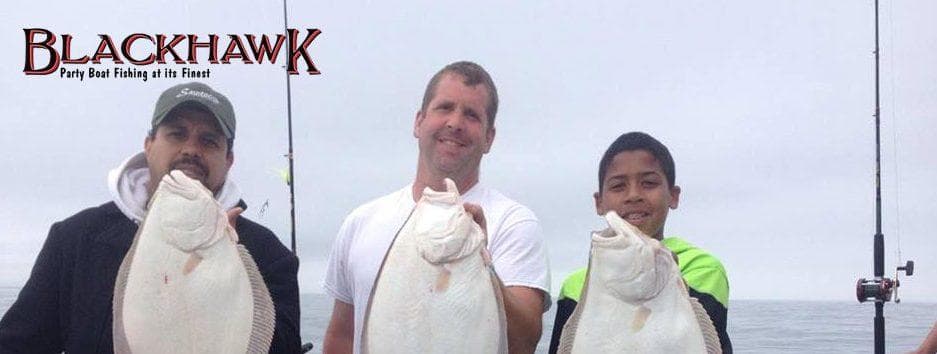 Three anglers displaying flatfish catches aboard charter boat