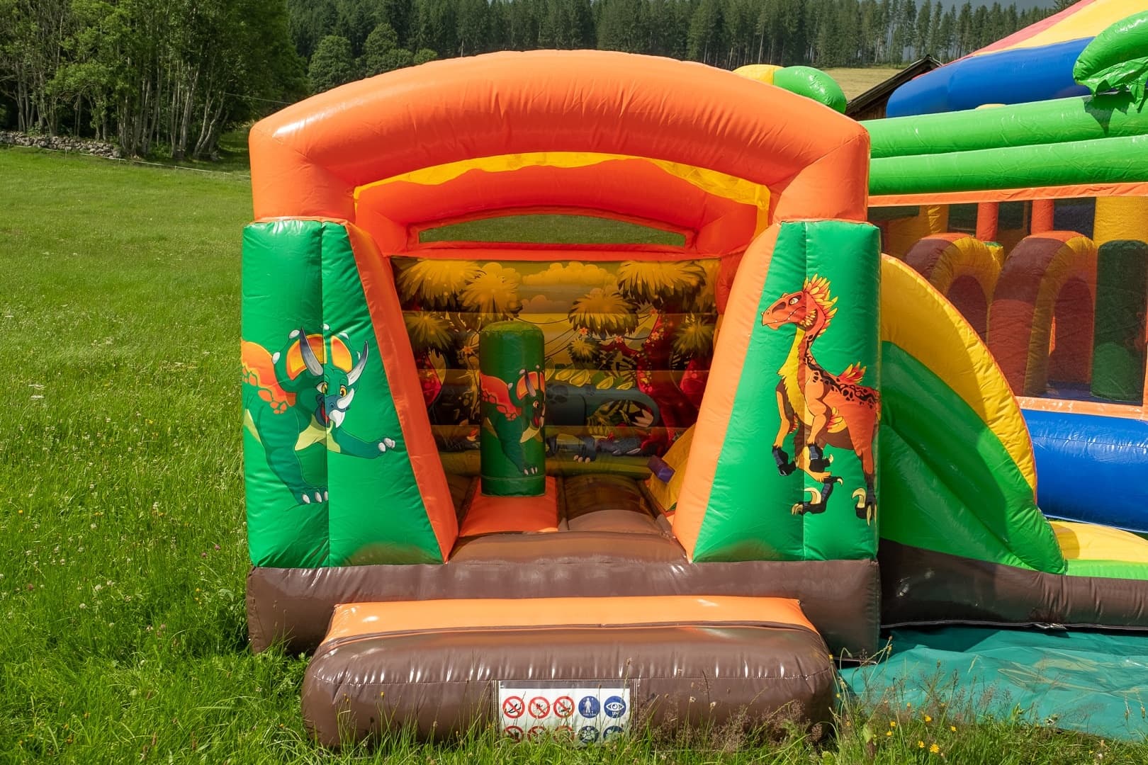 Inflatable kids play tunnel and slide set up on green outdoor lawn
