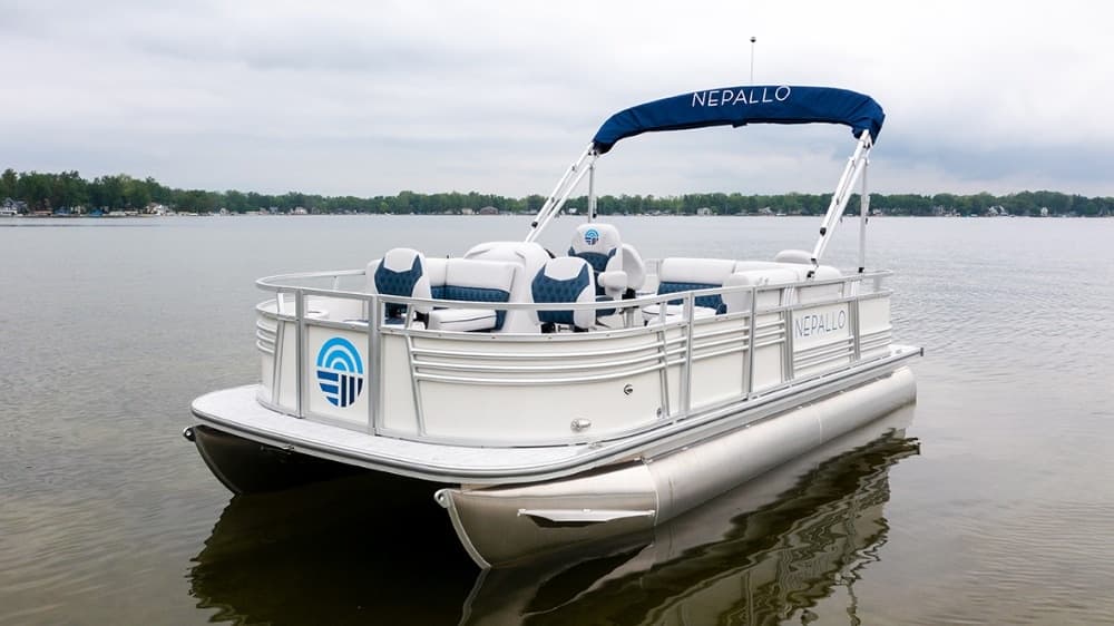Pontoon boat moored on calm lake shoreline for leisure cruise
