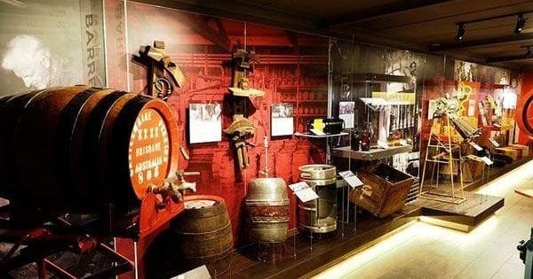 Brewery museum exhibit with wooden barrels and displays indoors