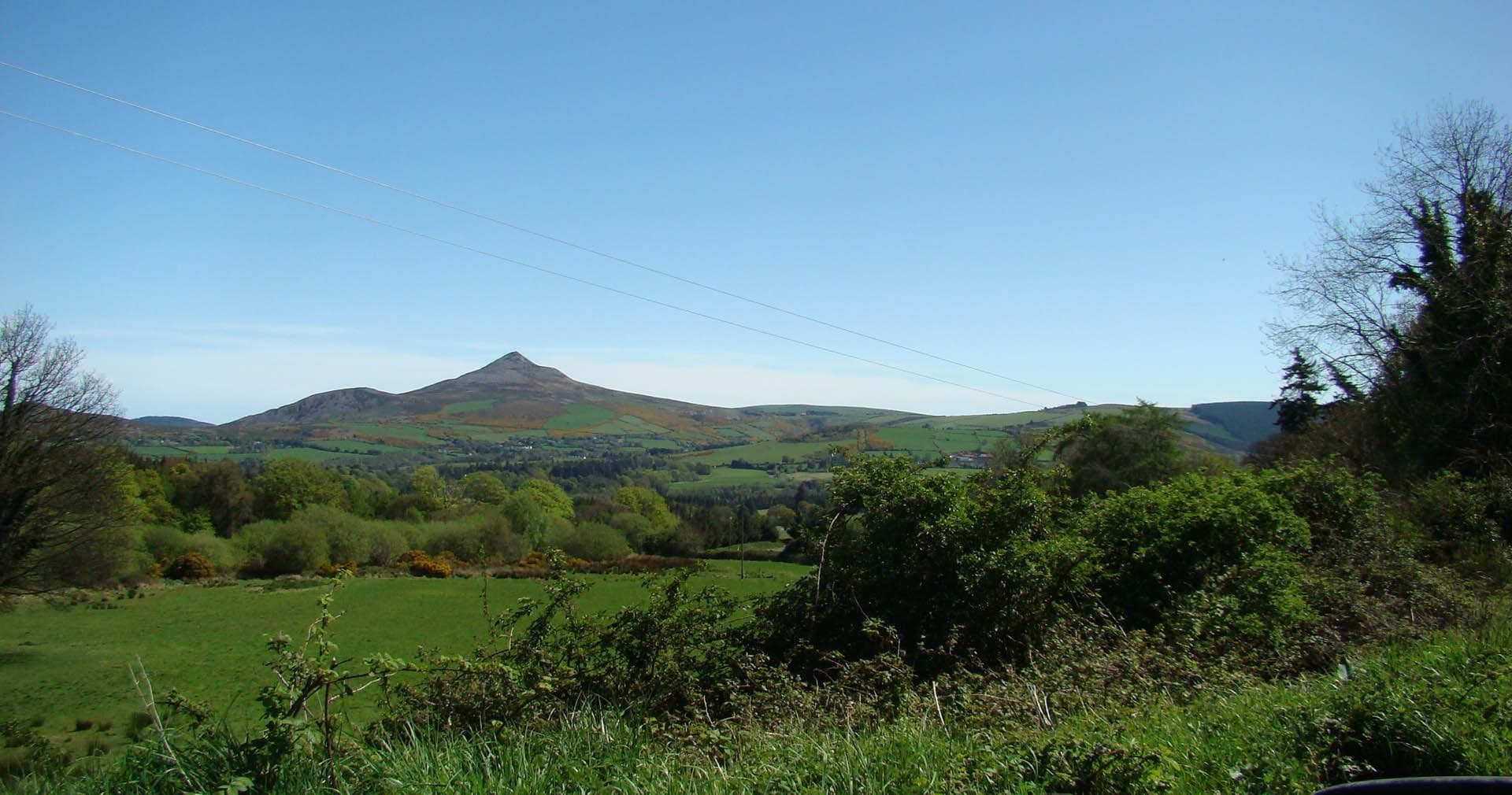 Rolling green hills and peak on rural hiking trail