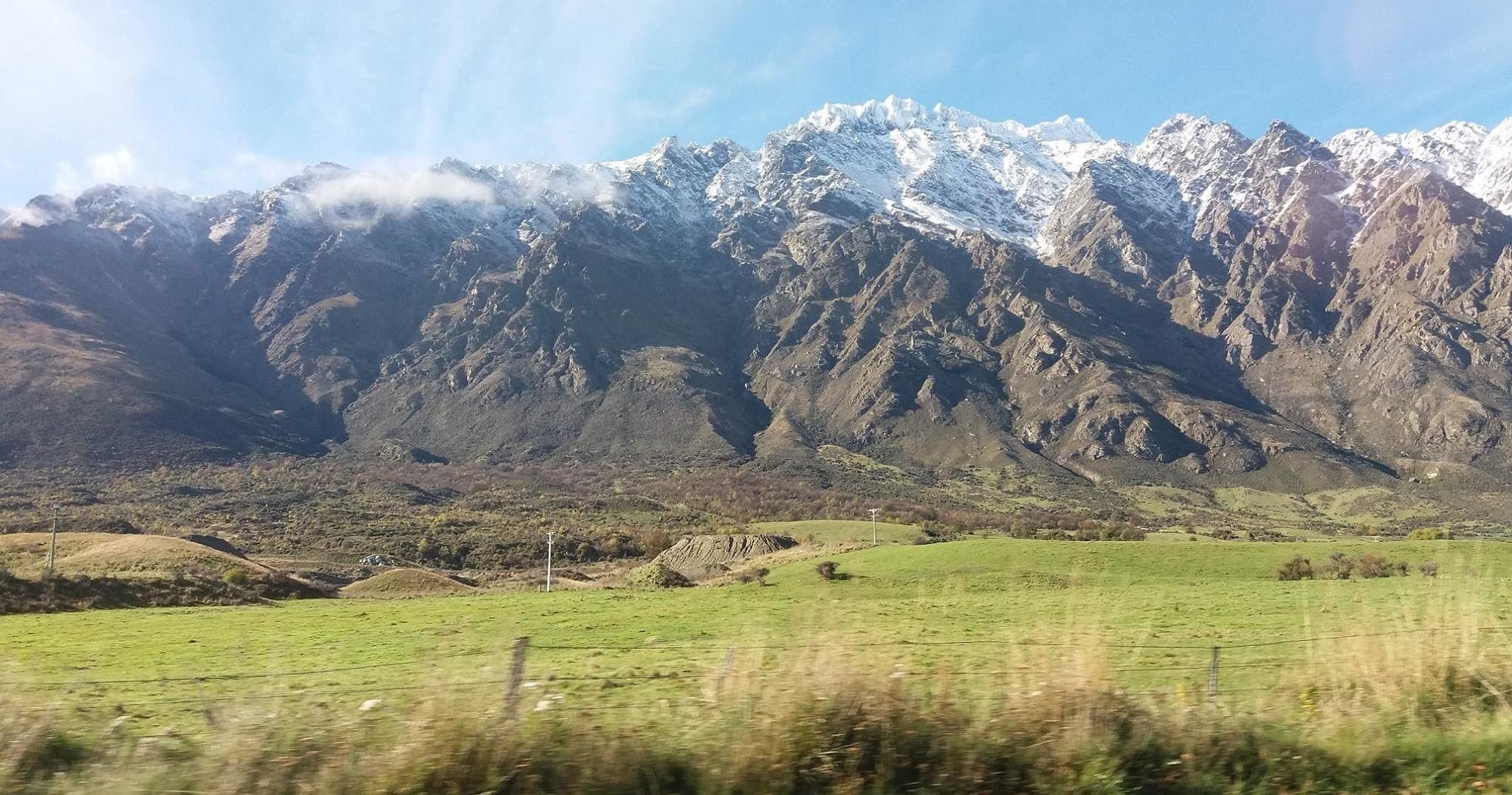 Snow-capped mountain range over grassy valley viewpoint