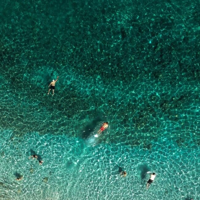 Aerial swimmers snorkeling in crystal-clear turquoise water