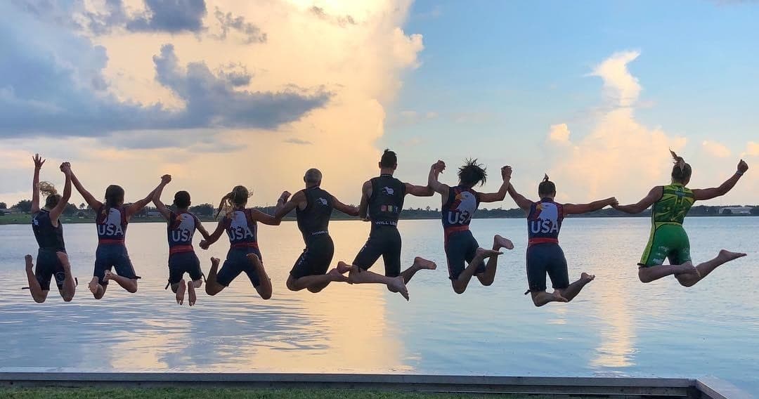 Group jumping off dock into lake at sunset, lakeside adventure