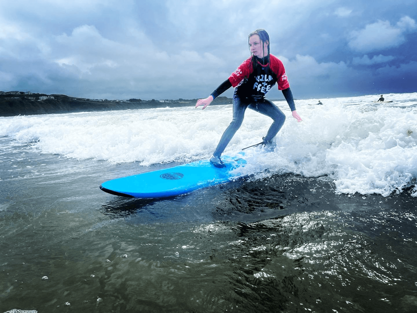Surfer riding breaking wave on ocean beach during lesson session